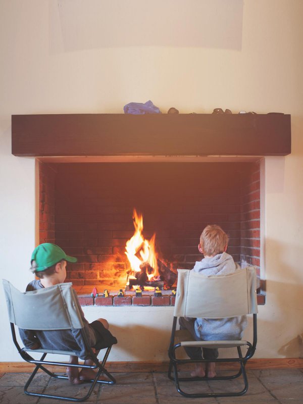 Kinder sitzen vor dem Kamin